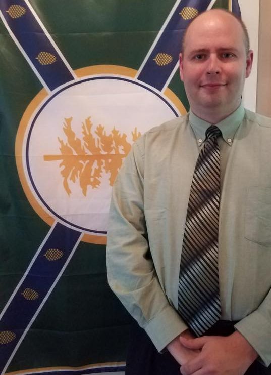 Jackman Town Manager Tom Kawczynski poses in front of his New Albion flag.