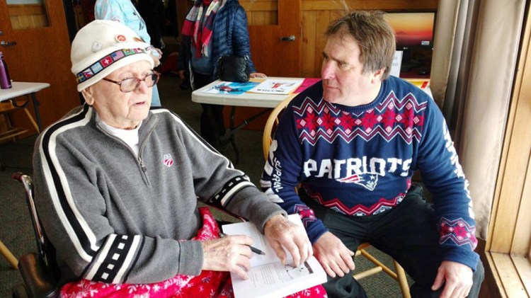 Wendall "Chummy" Broomhall, left, the oldest living member of the Chisholm Ski Club, talks as Scott Pitts listens at Black Mountain's Winter Carnival in February 2017. Pitts asked Broomhall to autograph his newly purchased copy of "A Century on Skis" by Scott Andrews. 