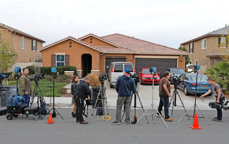 Members of the news media stand outside the home of David Allen Turpin and Louise Ann Turpin in Perris, California, Monday.