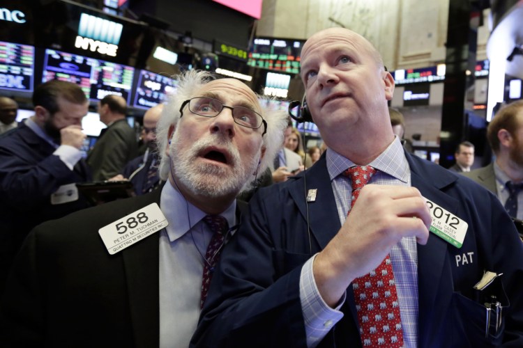 Traders Peter Tuchman, left, and Patrick Casey work on the floor of the New York Stock Exchang on Thursday.