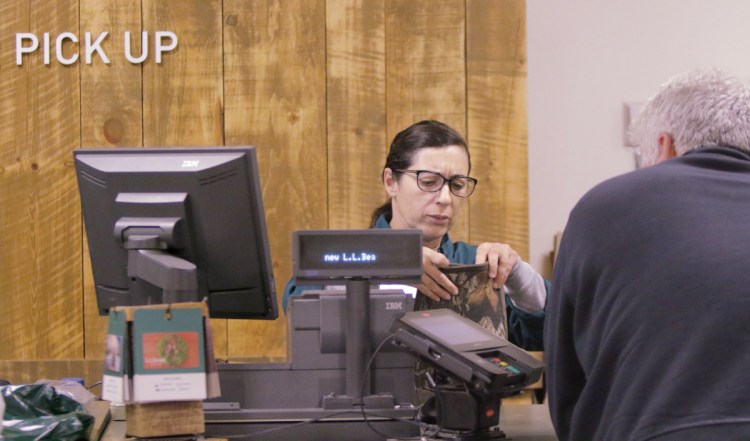 Maria Higgins helps a customer returning boots at the customer service area at L.L. Bean in Freeport in 2016. 