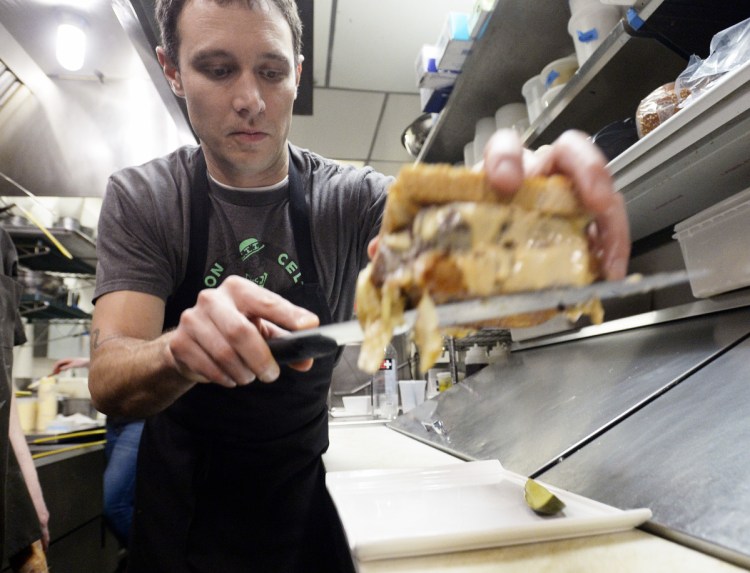 Chef Justin Hogan plates a Reuben sandwich last week at Nosh Kitchen Bar in Portland. These days, Nosh buys its corned beef from a wholesaler because city health regulations for curing meats have become too onerous.