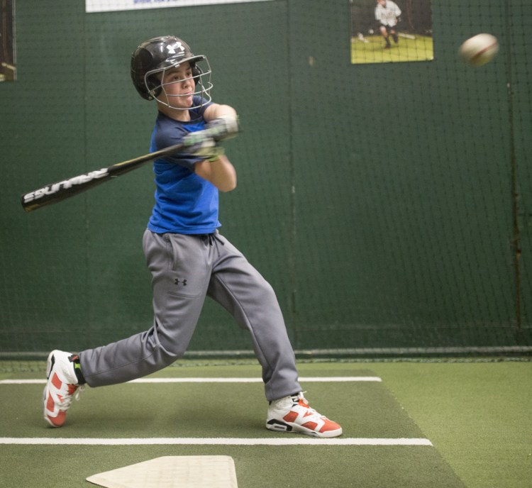Thomas Lewis, 12, hits in the batting cage at the Westbrook Community Center during practice with his Little League team, which is using the new baseball bats mandated for youth baseball leagues.