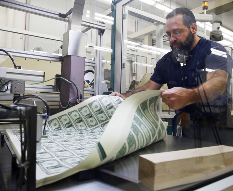 Vincent Tacconelli aerates sheets of dollar bills on Nov. 15. Most economists expect inflation to edge up and end the year a few tenths of a percentage point above the Federal Reserve's target.