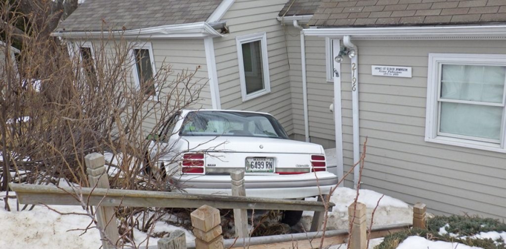 After going airborne and slamming into the home's roof, the car came to rest against the structure's exterior wall.