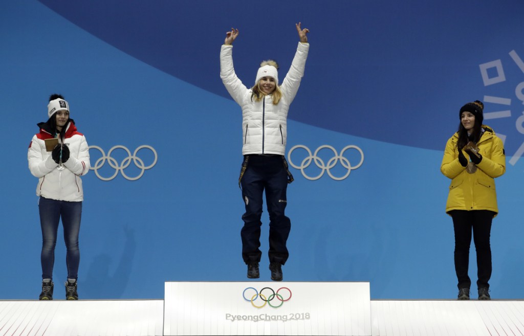 Silver medalist in the women's super-G Anna Veith, left, of Austria, and bronze medalist Tina Weirather, right, of Liechtenstein, applaud as gold medalist Ester Ledecka, of Czech Republic, celebrates during their medals ceremony at the 2018 Winter Olympics in Pyeongchang, South Korea on Saturday.
