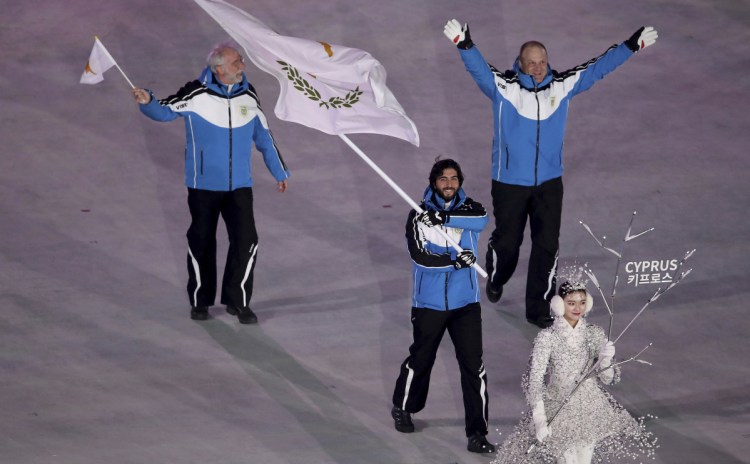 Joined by team officials, Dinos Lefkaritis carries the Cyprus flag in the Feb. 9 opening ceremony of the 2018 Winter Olympics in South Korea, where he is the island nation's only competitor.