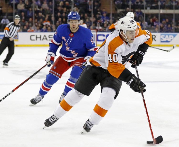 Flyers center Jordan Weal carries the puck with Peter Holland of the Rangers in pursuit during Philadelphia's 7-4 victory Sunday in New York.