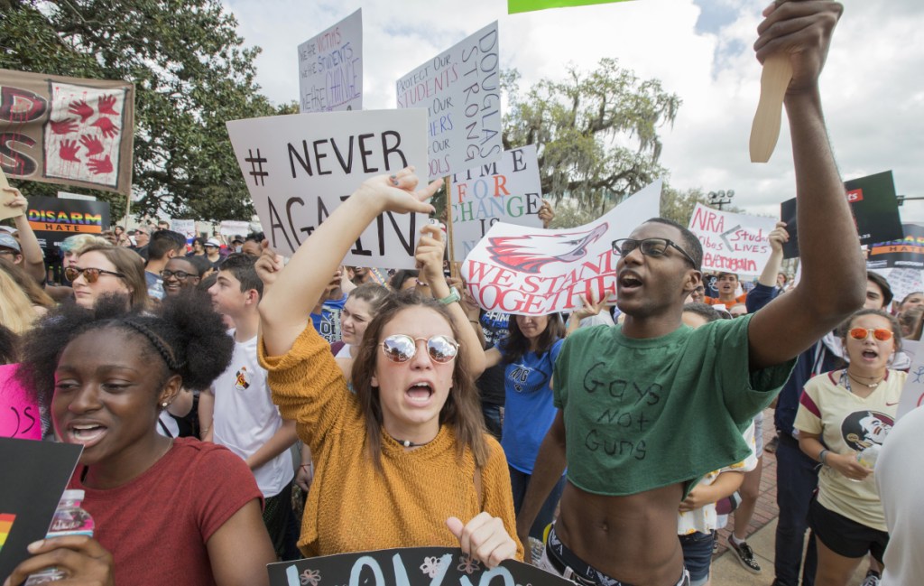 Therese Gachnauer, center, an 18-yea-old senior from Chiles High School, and Kwane Gatlin, right, a 19-year-old senior from Lincoln High School, both in Tallahassee, join fellow students protesting gun violence on the steps of the old Florida Capitol in Tallahassee, Fla., on Wednesday. Students at schools across Broward and Miami-Dade counties in South Florida planned short walkouts Wednesday, the one-week anniversary of the deadly shooting at Marjory Stoneman Douglas High School.
