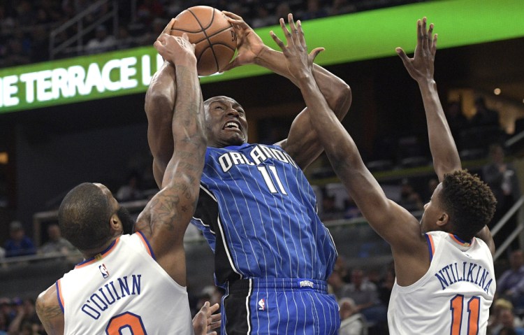 Bismack Biyombo of the Orlando Magic has his shot blocked by Kyle O'Quinn of the New York Knicks as Frank Ntilikina helps defend during the first half of the Knicks' 120-113 victory Thursday night.