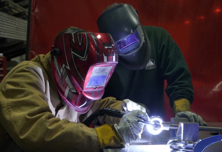 Biddeford High School student Sam Roy, 17, welds at DeepWater Buoyancy in Biddeford under the watchful eye of his mentor, Joe Woods, a welder/fabricator at the manufacturer of sub-sea buoyancy products. Last year, Roy became the first junior at the Biddeford Regional Center of Technology, which matched him with DeepWater Buoyancy, to obtain an American Welding Society certification.