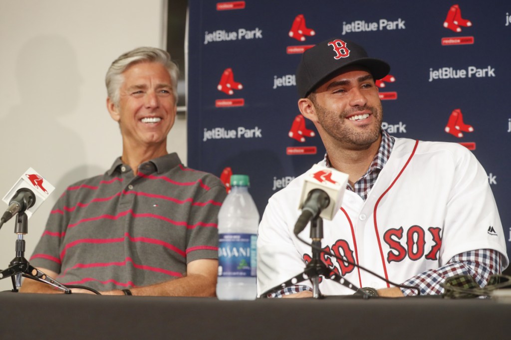 Boston Red Sox baseball player J.D. Martinez, right, smiles alongside David Dombrowski, president of baseball operations, during a news conference announcing his signing with the team, Monday, Feb. 26, 2018, in Fort Myers, Fla. (AP Photo/John Minchillo)