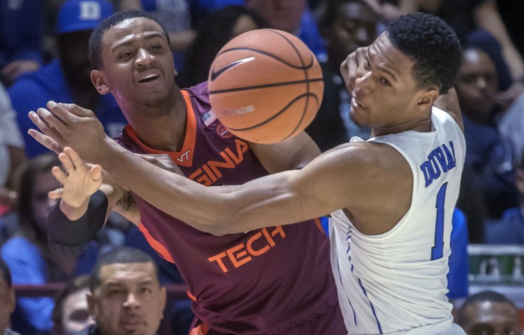 Nickeil Alexander-Walker of Virginia Tech, left, and Trevon Duval of Duke compete for a loose ball Monday night during the first half of Virginia Tech's 64-63 victory against the fifth-ranked Blue Devils.