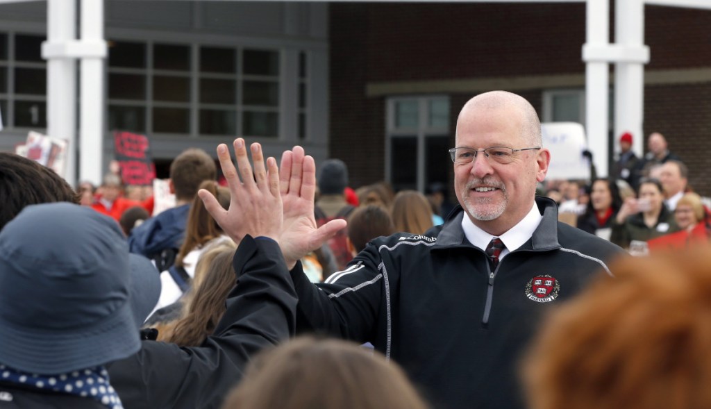 Scarborough High School Principal David Creech gets high-fives from students as they enter the building after February vacation.