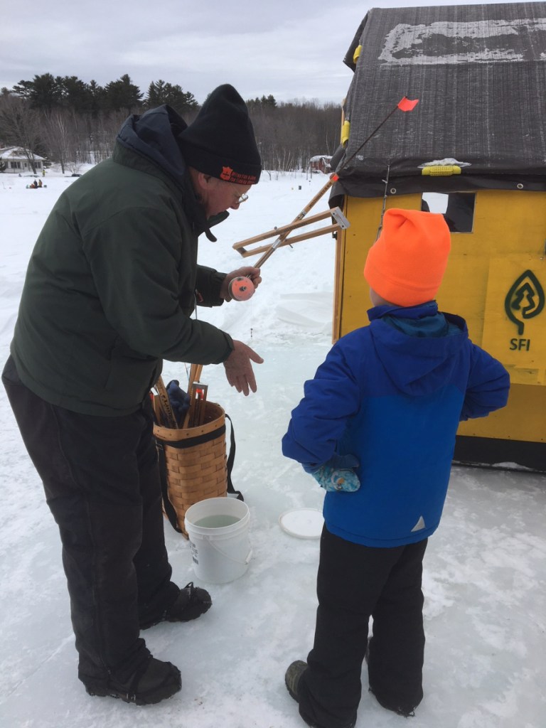 Alan Hart, a member of the Wilton Fish and Game Association, shows a youngster an ice fishing trap during last year's ice fishing clinic. A free ice fishing clinic for all ages will be held from 10 a.m. to 2 p.m. Feb. 17, as part of the ice fishing derby at Wilson Lake.