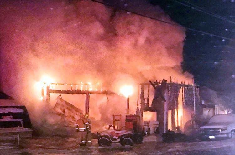 Flames light up the pre-dawn sky Saturday in Belgrade. The Belgrade Boat Shop was destroyed in the blaze.