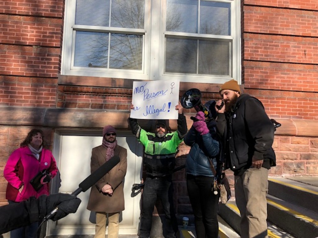 Mindy Saint Martin's brother, John Reynolds, speaks to the crowd Saturday outside Waterville's City Hall. At left in the pink jacket is her mother, Jodie Reynolds, of Clinton; and next to her is Evan Fisher, the Saint Martins family's attorney.