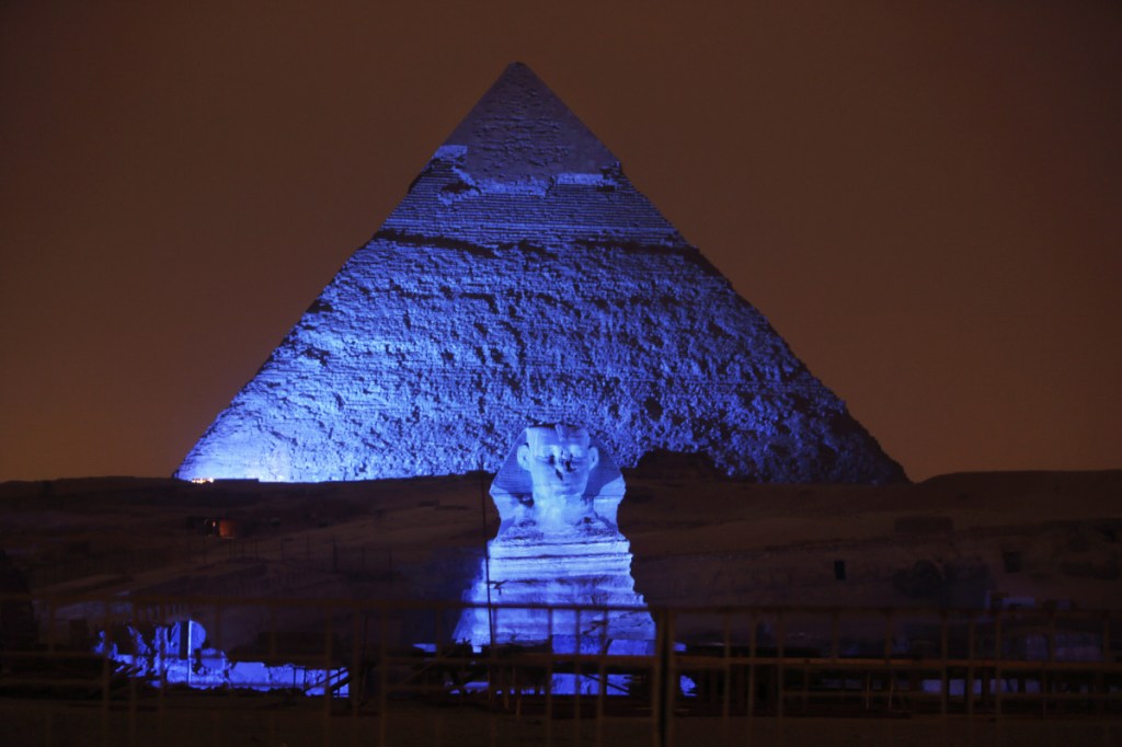 The Sphinx and the historical site of the Giza Pyramids are illuminated with blue light on Oct. 24, 2015, as part of the celebration of the 70th anniversary of the United Nations in Giza, just outside Cairo, Egypt. Archaeologists in Egypt say they have discovered a 4,400-year-old tomb near the pyramids outside Cairo. Egypt's Antiquities Ministry announced the discovery Saturday and said the tomb likely belonged to a high-ranking official known as Hetpet during the 5th Dynasty of ancient Egypt.