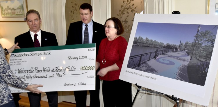 The City of Waterville received a $150,000 donation from Kennebec Savings Bank that will help fund the $1.5 million RiverWalk at Head of Falls project. The donation will go toward the project's amphitheater. Waterville City Manager Mike Roy, left, KSB President and CEO Andrew Silsby and Lisa Hallee, co-chair of the Riverwalk Advisory Committee, receive a mock check at the bank in Augusta on Monday.