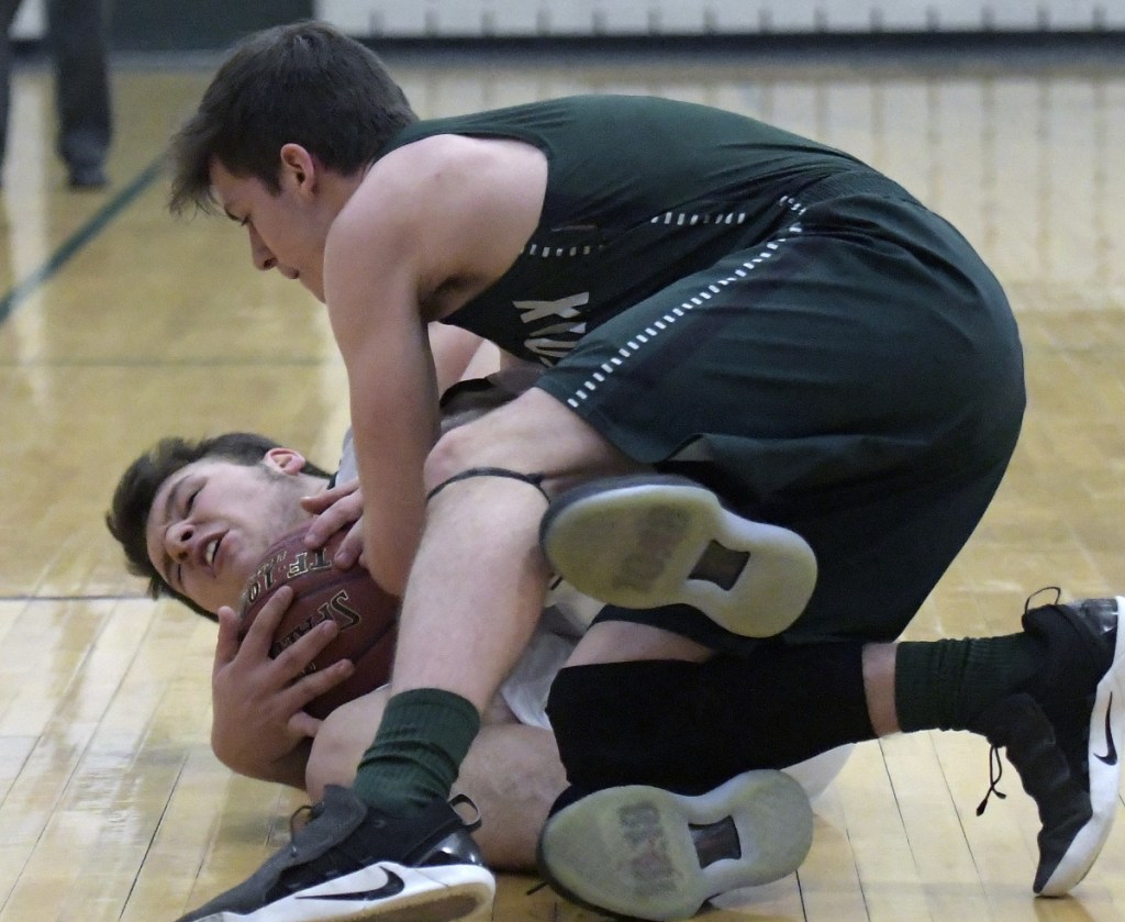 Winthrop's Sam Figueroa, left, tries to hang on to the ball as Spruce Mountain's Brett Frey looks to pry it loose during a Mountain Valley Conference game Monday night in Winthrop.
