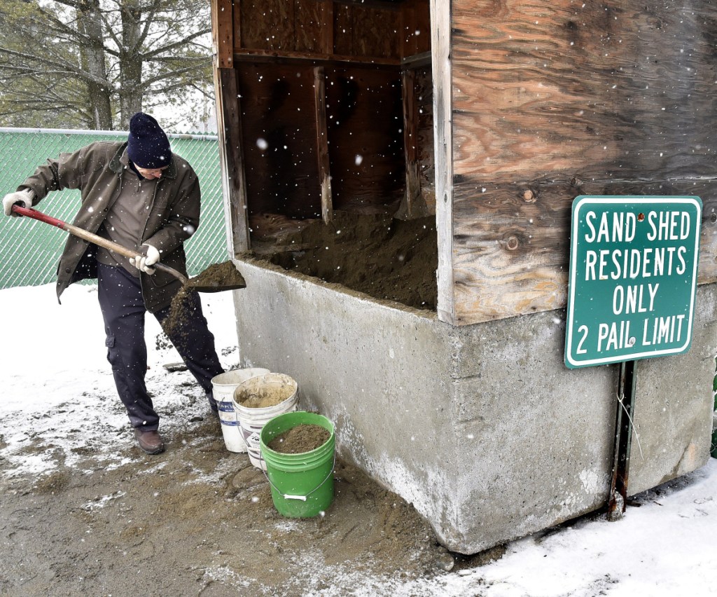 As snow falls Tuesday, Norton Webber fills buckets with sand at the Waterville Public Works department to stem icy conditions as a steady stream of residents prepared for Wednesday's snowstorm.