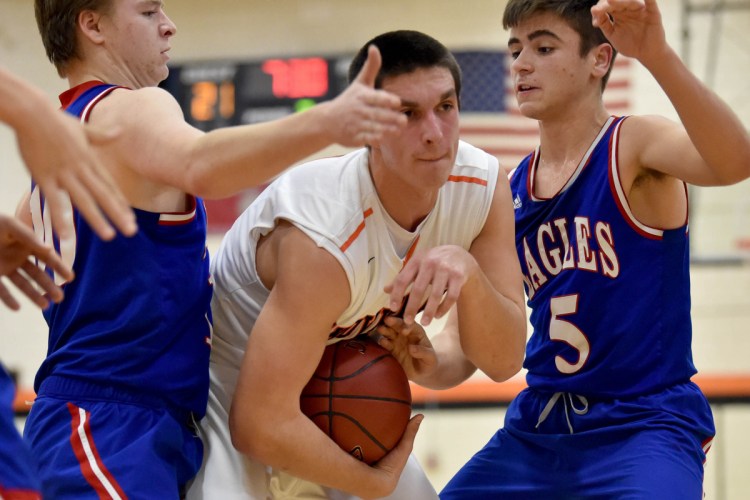 Skowhegan's Marcus Christopher, center, battles for a rebound with Messalonskee's Colby Charette, left, and Chase Warren during a Kennebec Valley Athletic Conference Class A game Tuesday in Skowhegan.