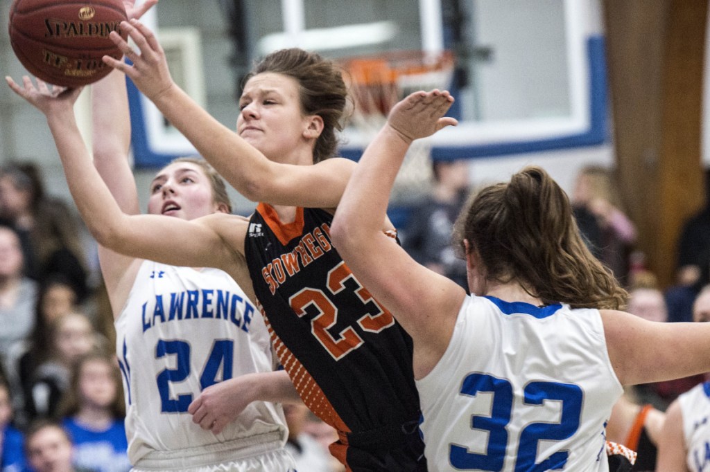 Skowhegan's Alyssa Everett (23) drives to the basket as she is defended by Lawrence's Haley Holt (32) and Molly Folsom (24) in a Class A North game Thursday in Fairfield.