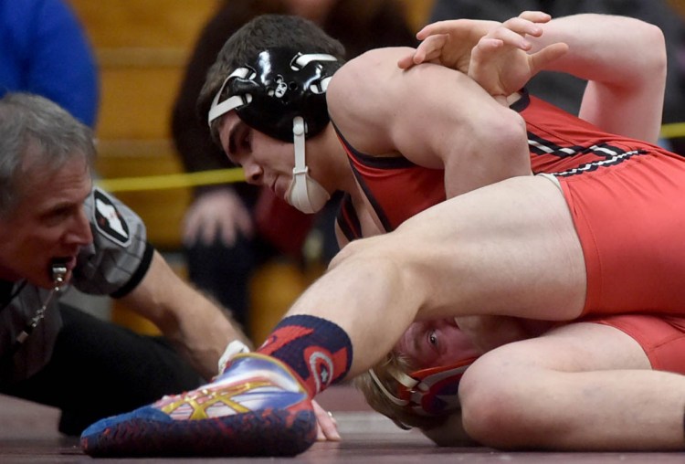 Messalonskee's Austin Pelletier, bottom, battles with Cony 's Nic Mills in the 182-pound weight class at the Class A North wrestling championships last season in Newport.