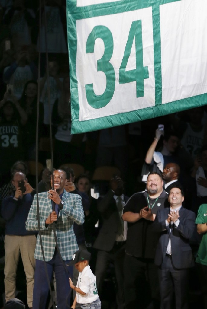 Former Boston Celtics star Paul Pierce, left, raises a banner during a ceremony to retire his number following a game against the Cleveland Cavaliers on Sunday in Boston.