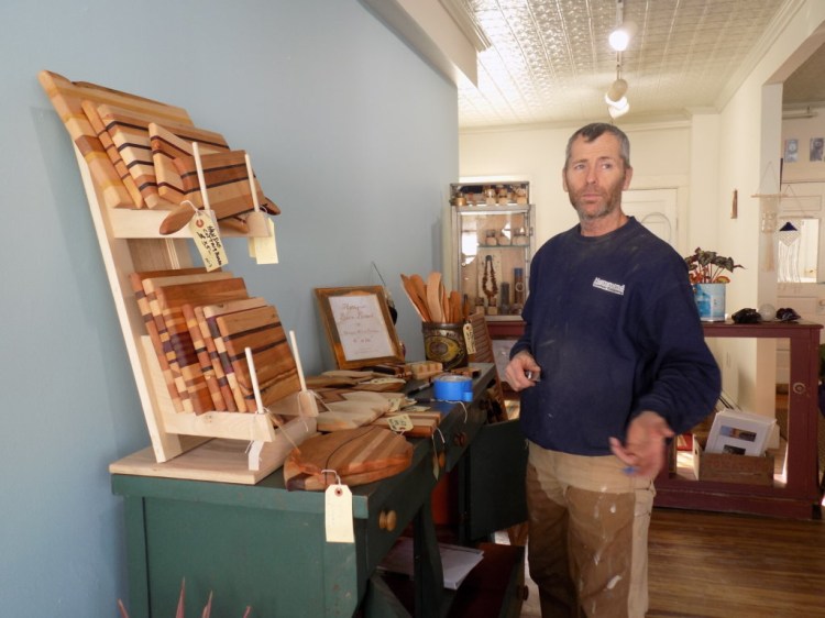 Vera's Iron and Vine on Front Street in Farmington now carries the work of several local artisans. John Nichols sets up a display of his wooden pieces.