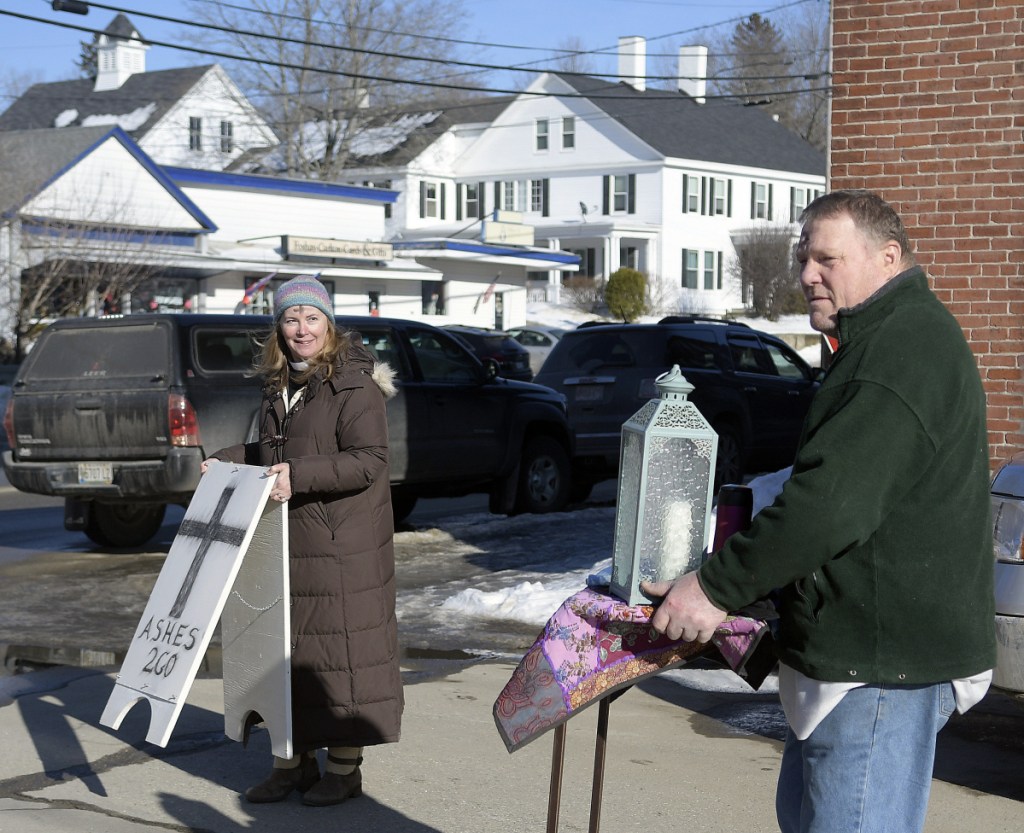 Rev. Susan Taylor, of St. Andrew's Episcopal Church, and parishioner Bob Somes set up a spot in downtown Winthrop on Wednesday to place the sign of the cross on people with ashes.