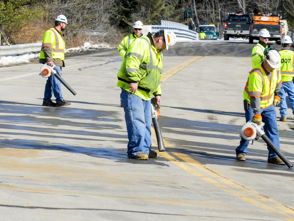 Department of Transportation workers blow-dry the road as they prepare to paint striping on Wednesday at the new bridge at Exit 109 over Interstate 95 in Augusta. The bridge was damaged by an unidentified vehicle or piece of equipment last year.