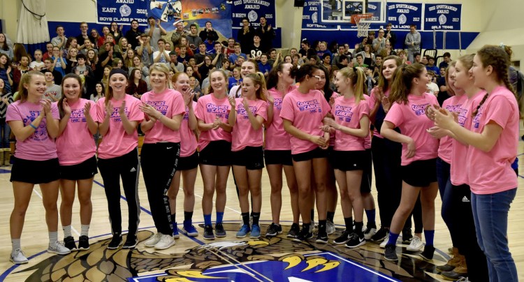 Students and staff at Erskine Academy applaud the girls basketball team, which was recognized for raising $10,000 for the American Cancer Society during a ceremony Tuesday at the South China school.