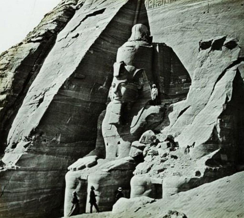 The Temple of Abu Simbel at the southern border of Egypt, built by pharaoh Ramesses II about 1250 B.C. This image is a stereoview photograph on glass taken about 1865 and shows some early tourists at the base of the 65-foot colossi of the king.