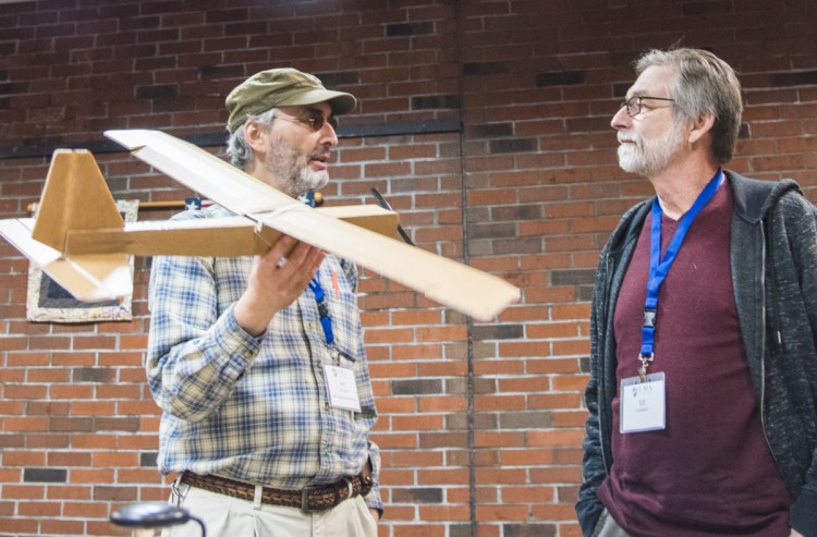 Jon Silverman, left, of Augusta, a recently certified FAA drone pilot, holds a drone made of cardboard Saturday while speaking to Ed Campbell, a land surveyor from Londonderry, N.H. The two were attending a conference at University of Maine at Augusta on using drones for business purposes.
