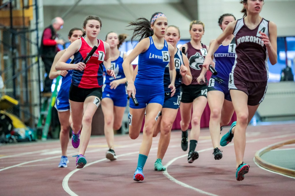 Gray-New Gloucester's Abby Dulac (7) and Lawrence's Brianna Meader (5) jockey for position at the start of the 4x800 relay at the Class B indoor track state championships.