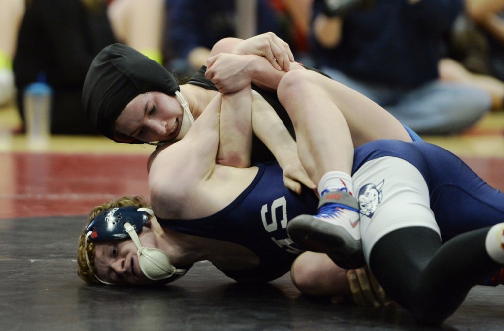 Zoe Buteau, top, of Lisbon/Oak Hill, wrestles Ashton James of Calais in the consolation semifinals at the Class B wrestling championships Saturday at Wells High School.