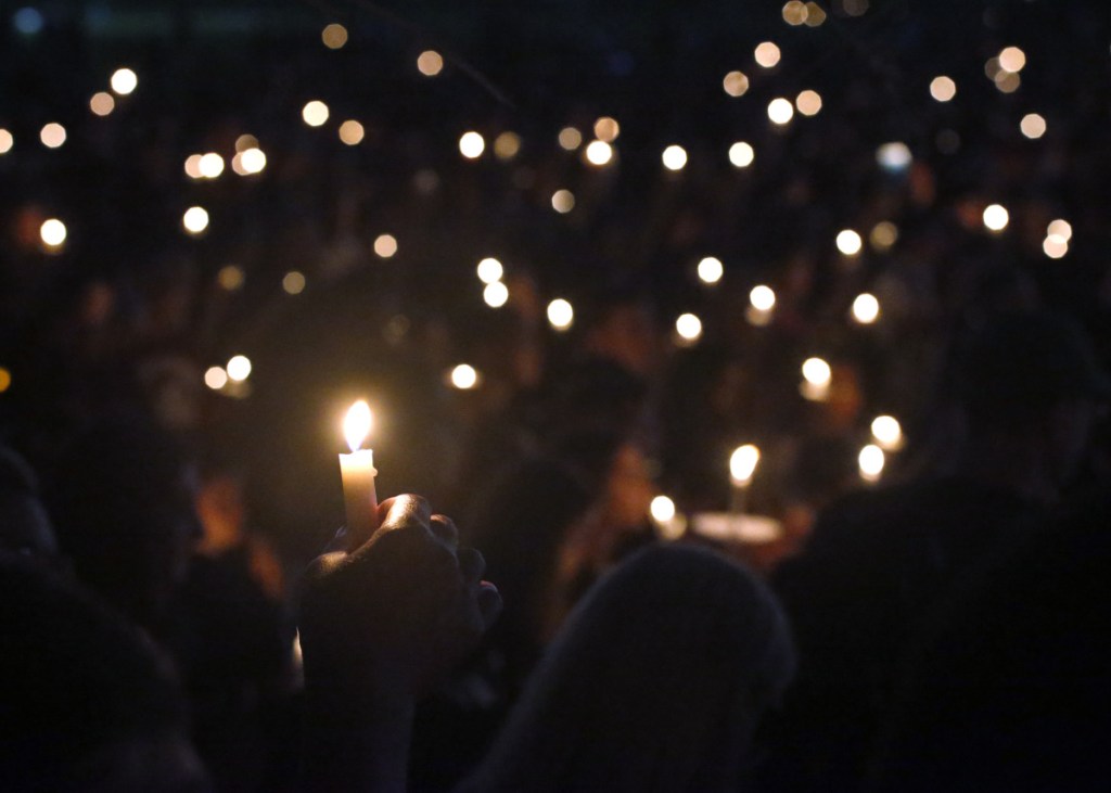 Attendees hold up their candles at a candlelight vigil for the victims of the shooting at Marjory Stoneman Douglas High School in Parkland, Florida.