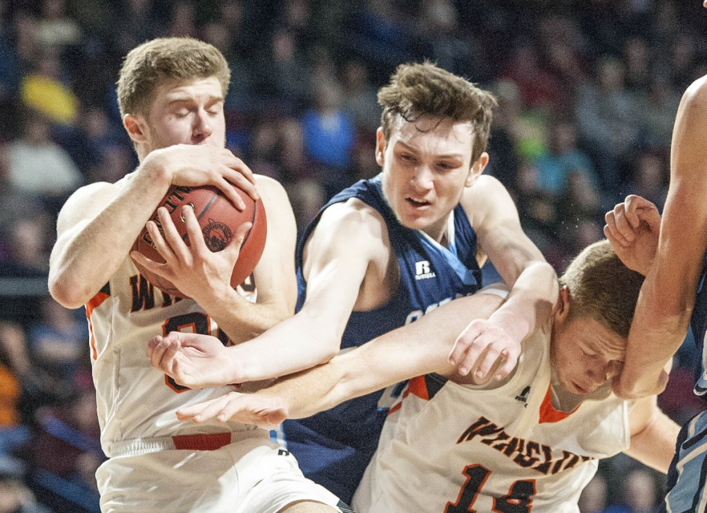 Winslow's Isaiah Goldsmith, left, grabs a rebound as Oceanside's Michael Norton climbs over Winslow's Jake Lapierre during a Class B North quarterfinal game Saturday afternoon at the Cross Insurance Center in Bangor.