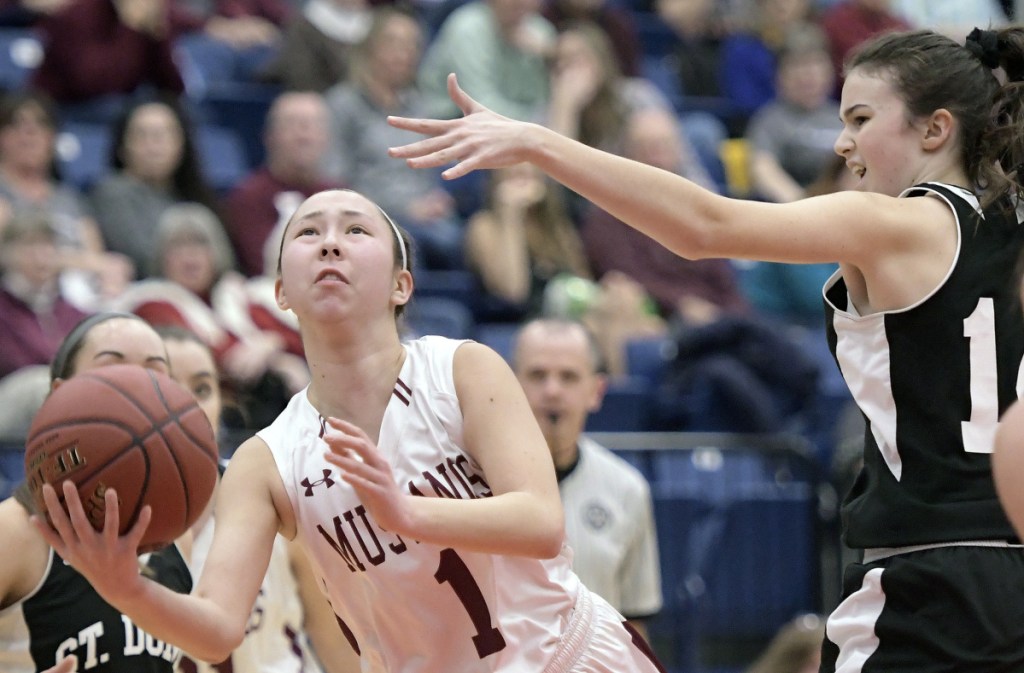 Staff photo by Andy Molloy 
 Monmouth guard Tia Day shoots as St. Dominic's Madison Leslie defends during a Class C South quarterfinal game Tuesday afternoon at the Augusta Civic Center.