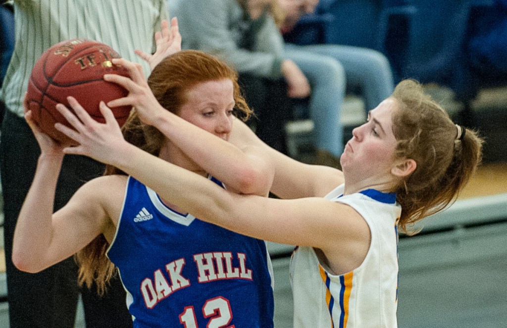 Lake Region's Rachel Shanks, right, pressures Oak Hill's Sadie Waterman in the backcourt during a Class B South quarterfinal game Tuesday in Portland.