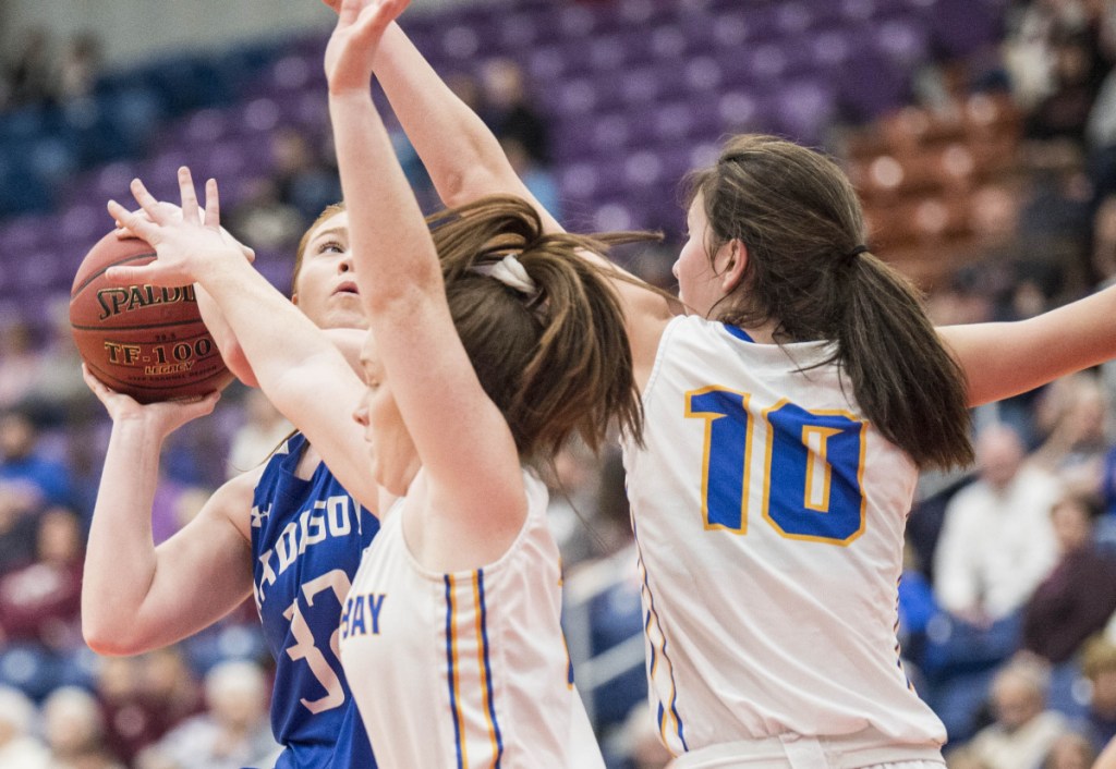 Madison's Lauren Hay, left, takes a shot as she is defended by Boothbay's Glory Blethen (10) and Josey Smith, center, in the Class C South semifinals Thursday at the Augusta Civic Center.