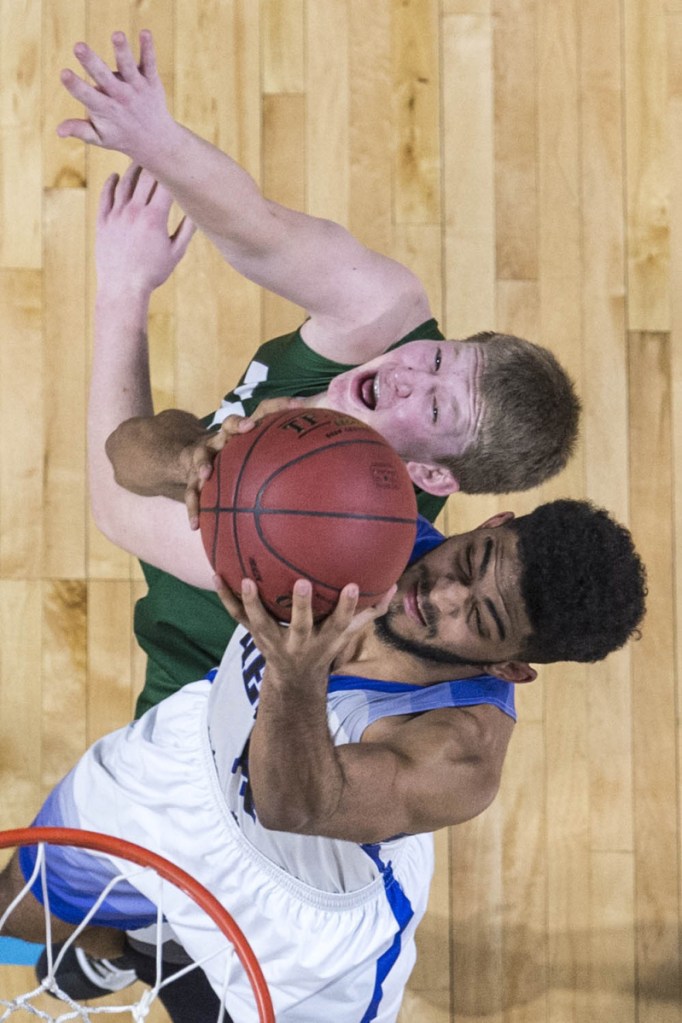 Hermon's Jacob Godfrey grabs a rebound over Mount Desert Island's Andrew Shea during the Class B North championship game Saturday at the Cross Insurance Center in Bangor.