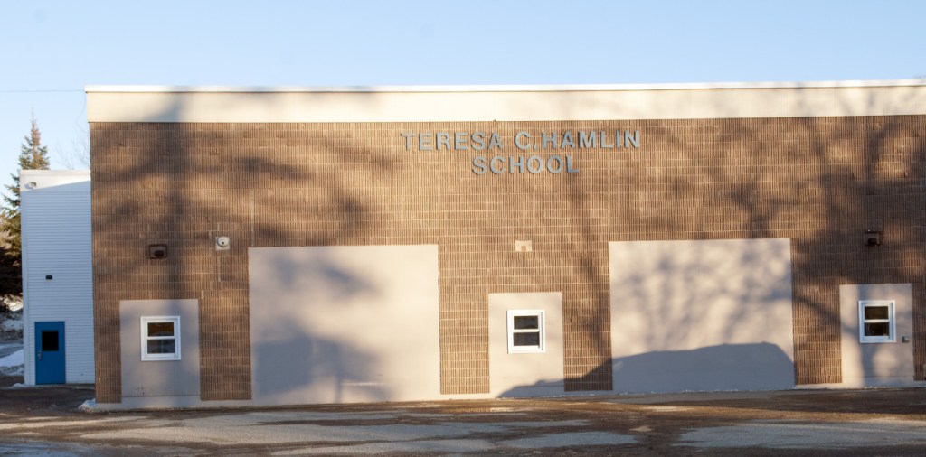 School officials have postponed a vote on closing the Teresa C. Hamlin School in Randolph.