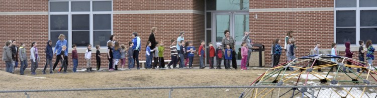 Students in the early grades stand outside the Mount View school complex in Thorndike after being evacuated because of a suspected chemical release Wednesday. Apparently a student released pepper spray in a classroom, affecting about 20 students.