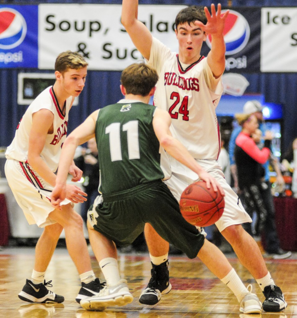 Winthrop's Beau Brooks dribbles behind his back to keep the ball away from Hall-Dale's Josh Nadeau, left, and Owen Dupont during the Class C South title game last Saturday at the Augusta Civic Center.