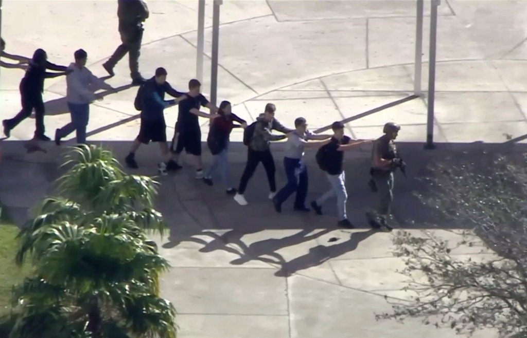 In this image from video, students from the Marjory Stoneman Douglas High School in Parkland, Fla., evacuate the school after the shootings on Feb. 14.