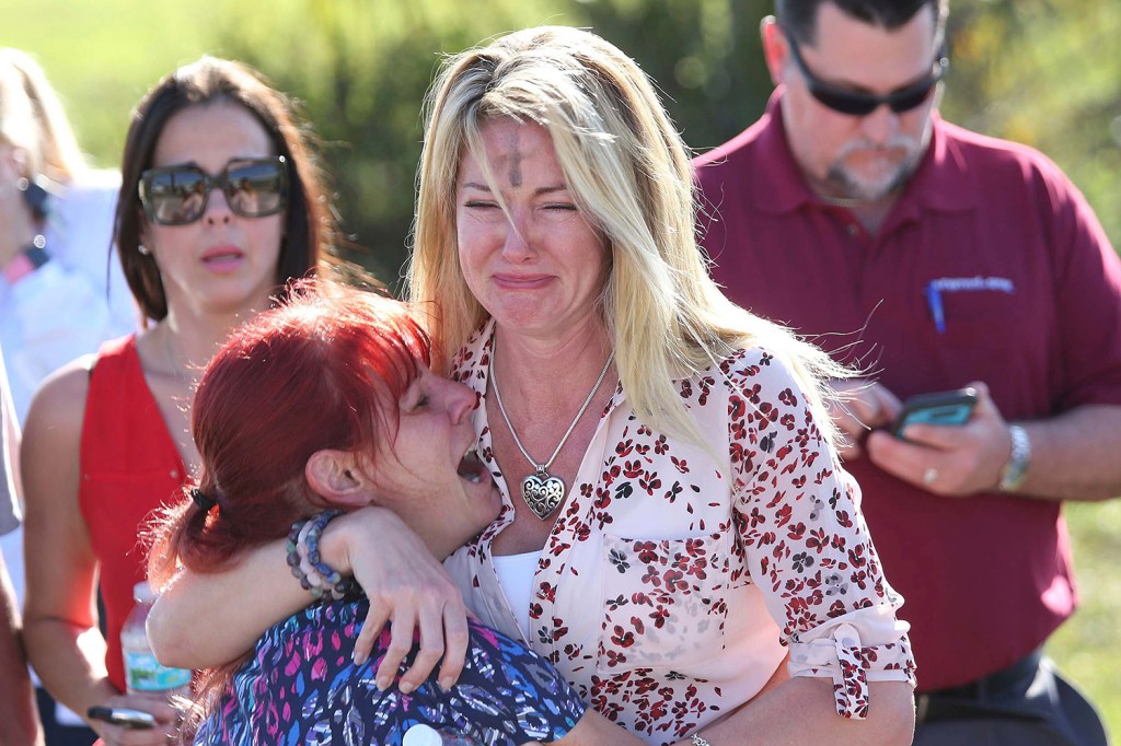 Parents wait for news after reports of a shooting at Marjory Stoneman Douglas High School in Parkland, Fla., on Wednesday.