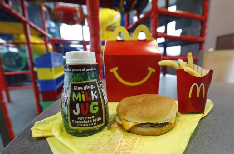A Happy Meal featuring non-fat chocolate milk and a cheeseburger with fries are arranged for a photo at a McDonald's restaurant. McDonald’s will soon remove cheeseburgers and chocolate milk from its Happy Meal menu. 