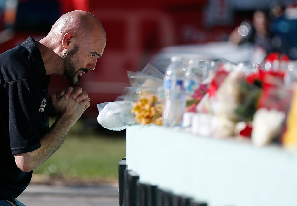 Kevin Siegelbaum, a special education teacher at Marjory Stoneman Douglas High School, leans in to pray Thursday, Feb. 15, 2018, in Parkland, Fla., during a community vigil at Pine Trails Park for the victims of the shooting at Marjory Stoneman Douglas High School. Nikolas Cruz, a former student, was charged with 17 counts of premeditated murder on Thursday. 
